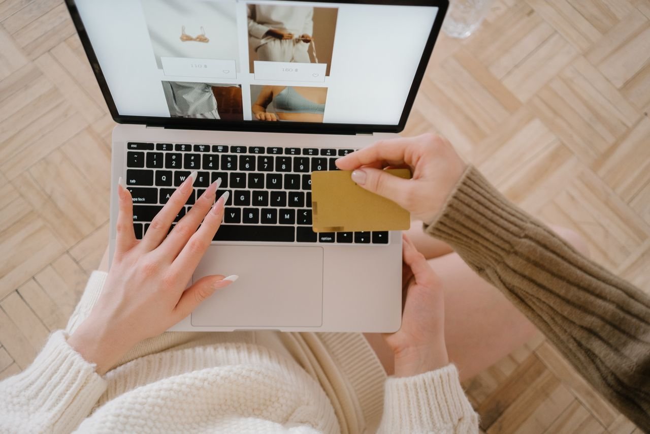 about-us Person shopping online using a laptop and credit card, highlighting e-commerce convenience.